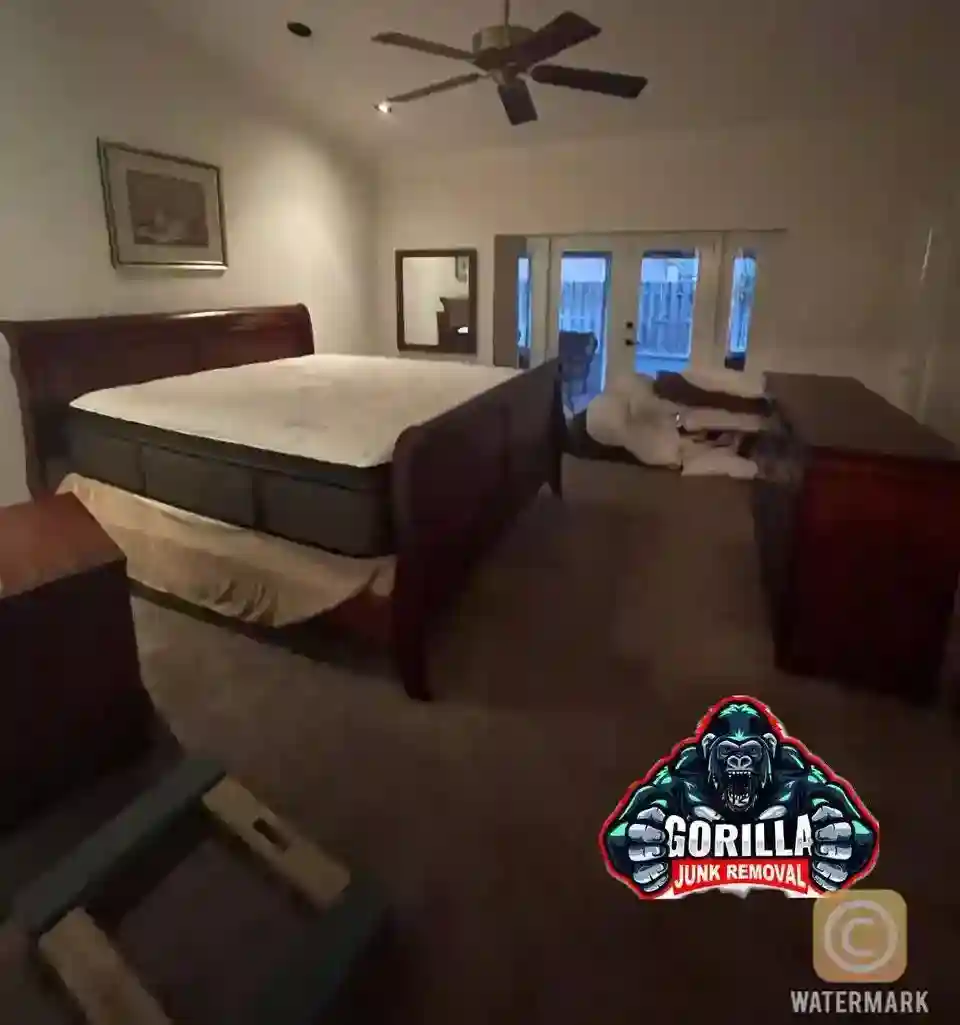 Bedroom cluttered with an old bed frame, dresser, and mattress before professional junk removal service
