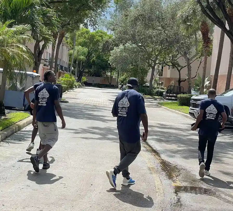 Gorilla Junk Removal team in branded shirts walking down a residential street to tackle a junk removal job