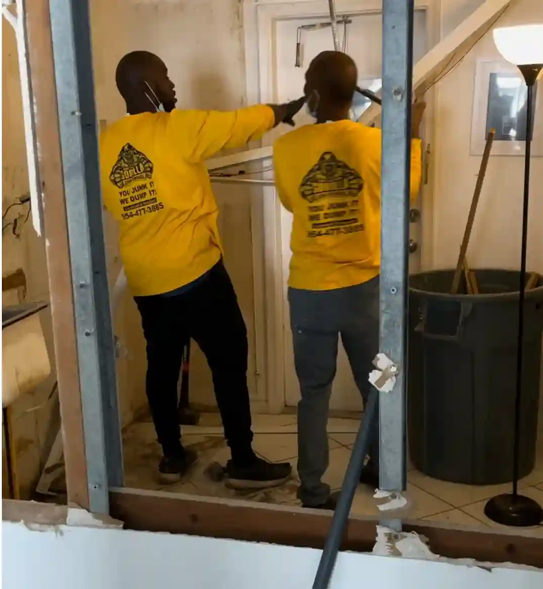 Gorilla Junk Removal team in yellow shirts working inside a home during renovation, clearing debris and preparing the space