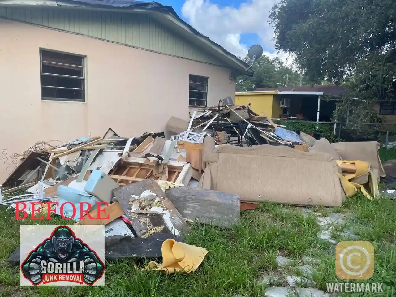 Overwhelmed by bulky junk? Pile of broken furniture, wood, and trash cluttering the side yard of a home before cleanup