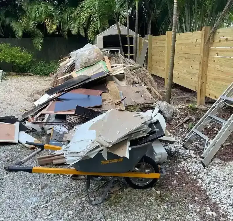 Pile of construction debris including drywall, wood, and flooring after a home renovation, ready for junk removal in Florida backyard