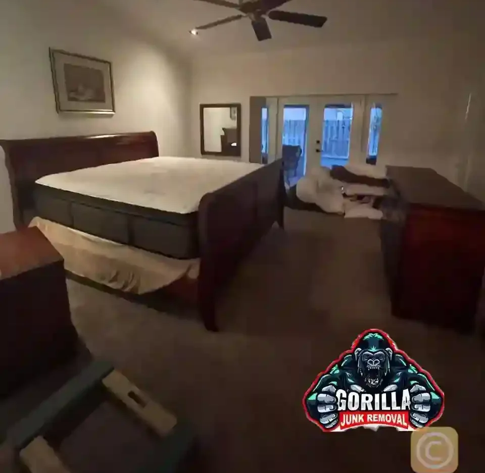 Bedroom cluttered with an old bed frame, dresser, and mattress before professional junk removal service