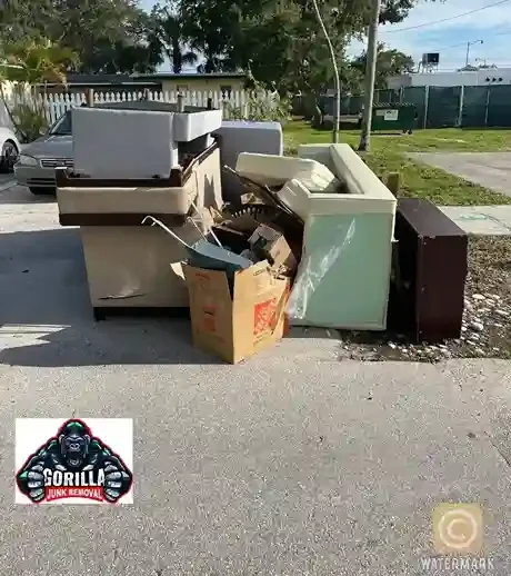 Driveway cluttered with old couches, chairs, and boxes before professional junk removal service in South Florida